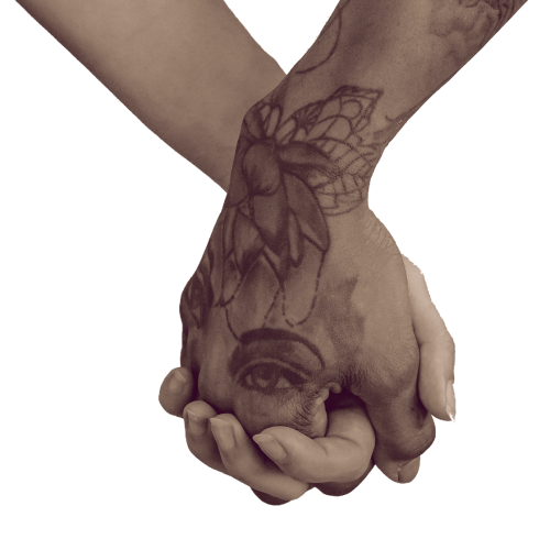 hands clasped, one white one brown with tattoos