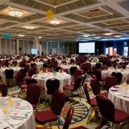 A wide-view shot of the banquet hall with the table set, but no guests yet.