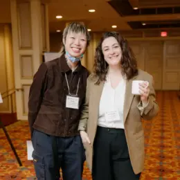 Two West Coast LEAF staff are smiling and holding coffee cups.