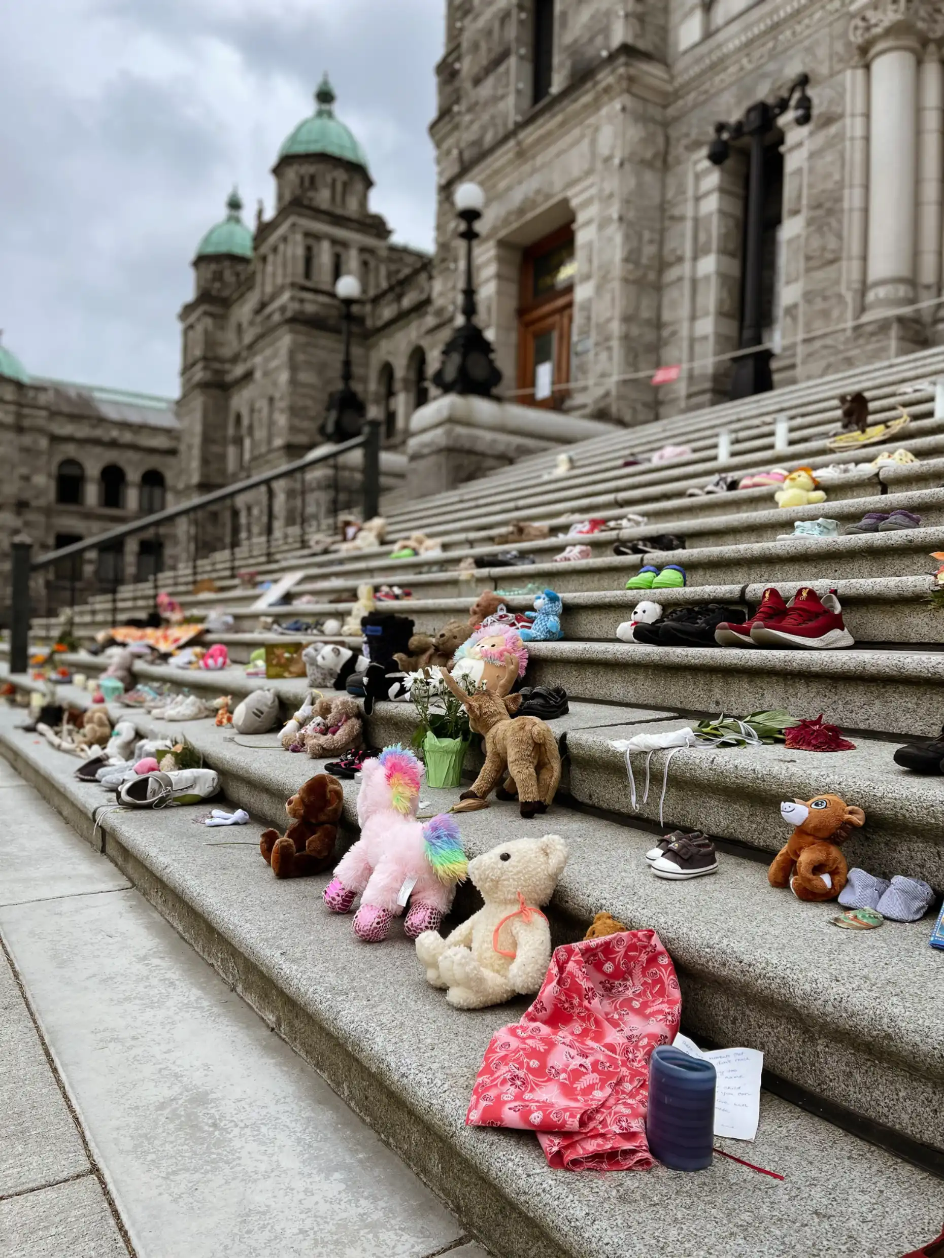 The stone steps of the legislature buildings are covered with a memorial of children's toys. 
