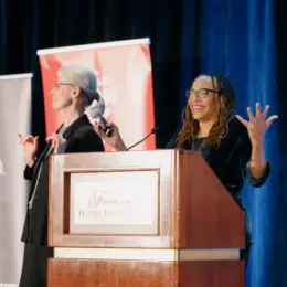 Black scholar, author and activist Dorothy Roberts presents the keynote address behind a podium on stage.
