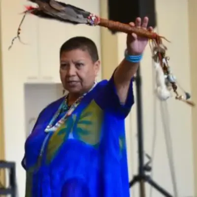 Elder Roberta Price from Snuneymuxw and Cowichan First Nations providing a Land Acknowledgement at a recent West Coast LEAF and SPARC BC event. She is wearing a blue dress and beaded necklaces.