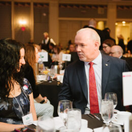 BC Premier John Horgan chats with other attendees at his table.