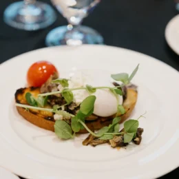 A close up of the delicious breakfast served: greens, mushrooms, ricotta, and a poached egg on toast.