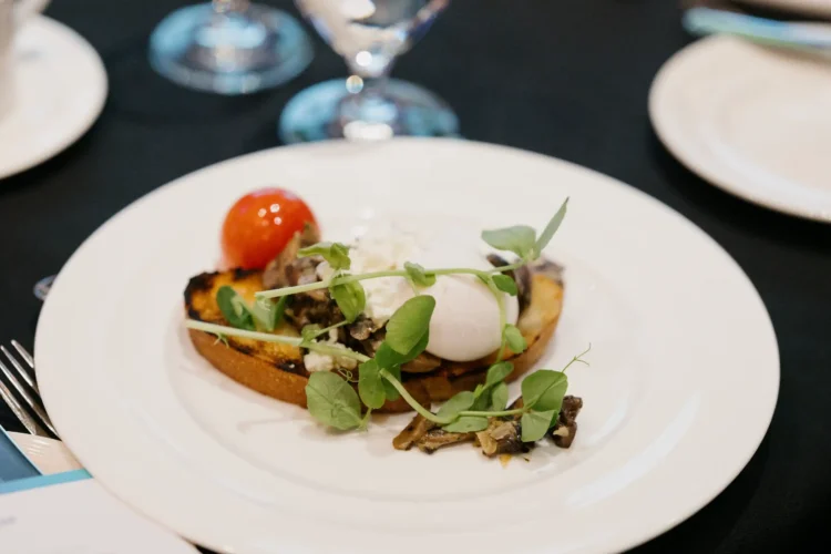 A close up of the delicious breakfast served: greens, mushrooms, ricotta, and a poached egg on toast.