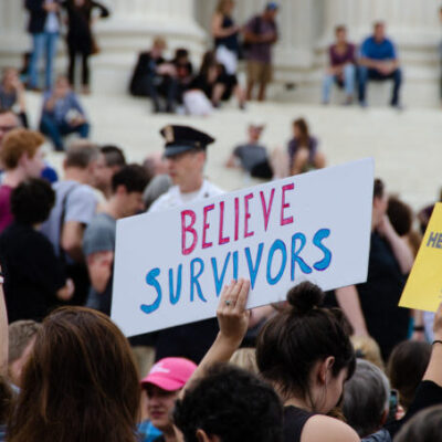 Protest with person holding sign that reads: believe survivors