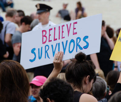 Protest with person holding sign that reads: believe survivors